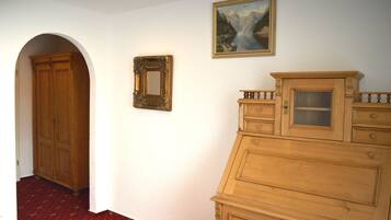 A hallway with a wooden wardrobe, a mirror, and a painting on the wall.