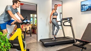 A gym with a stationary bike, treadmill, and exercise equipment. - ibis budget Strasbourg Sud Illkirch Geispolsheim (Geispolsheim)
