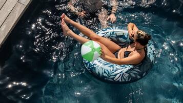 A person floating on an inflatable ring in a pool.