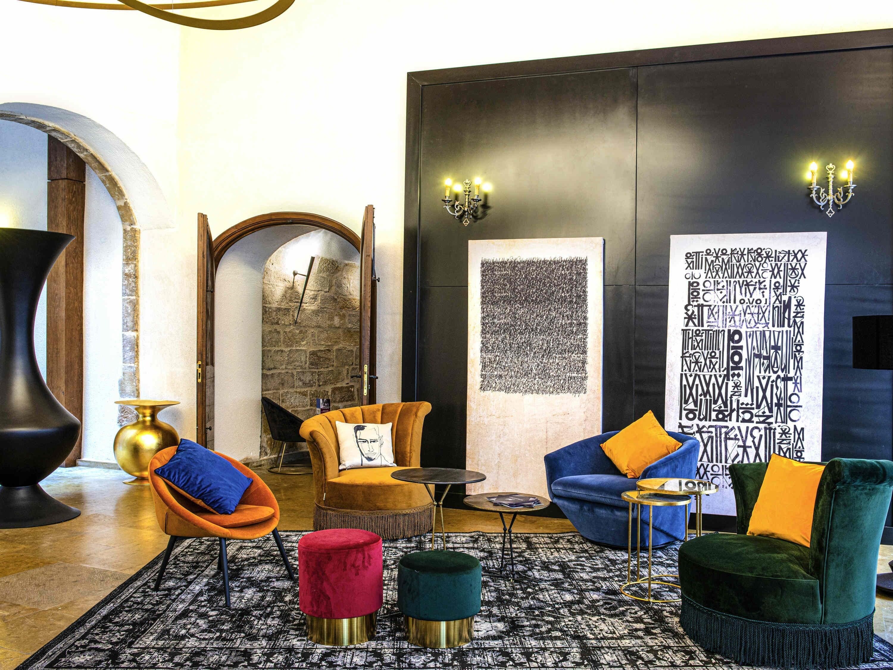 A modern lounge with a stone archway, a large abstract artwork, and contemporary furniture.