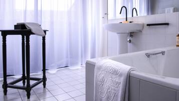 A modern bathroom with a bathtub, a sink, and a vanity table.