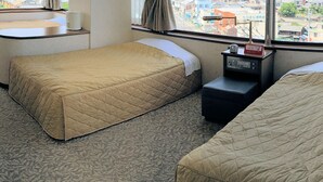 A hotel room with two beds, a small table, and a window with curtains. - Shimabara Hakusan Hotel (Shimabara)