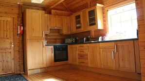 Una cocina de madera con armarios, un microondas y una estufa.