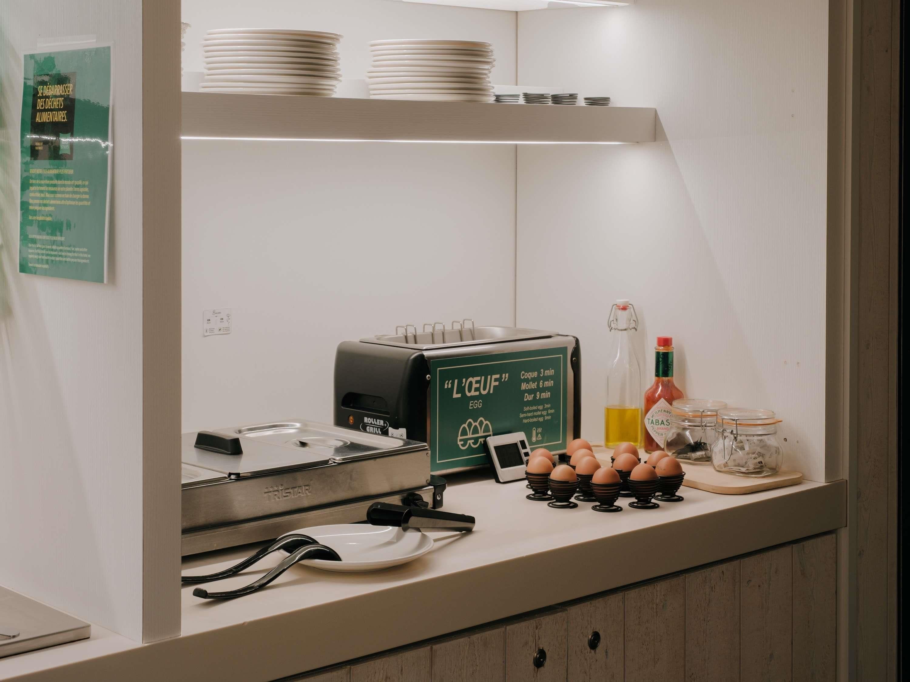 Una kitchenette con un tostador, una cafetera y una botella de aceite.