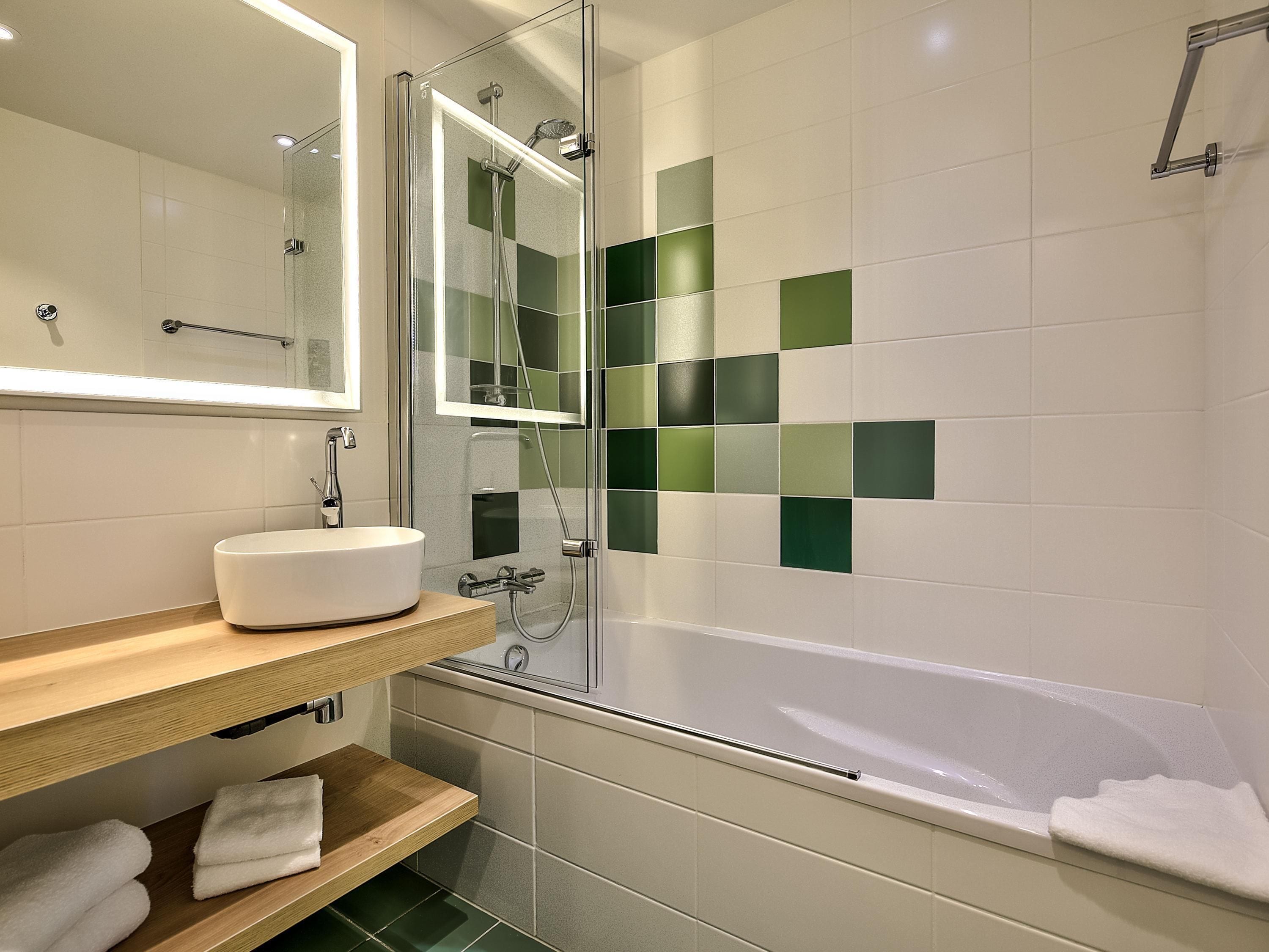 A modern bathroom with a glass-enclosed shower, a white sink, and a bathtub.