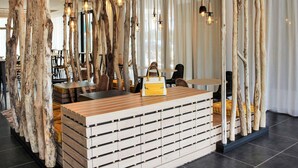 Een modern interieur met een houten receptiebalie, hangende pendantlampen en natuurlijke houten accenten.