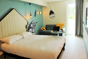 Een moderne slaapkamer met een groot bed, een bureau met een laptop en uitzicht op de omgeving.