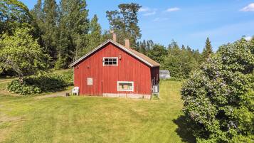 A red barn with a gabled roof, a small window, and a chimney.