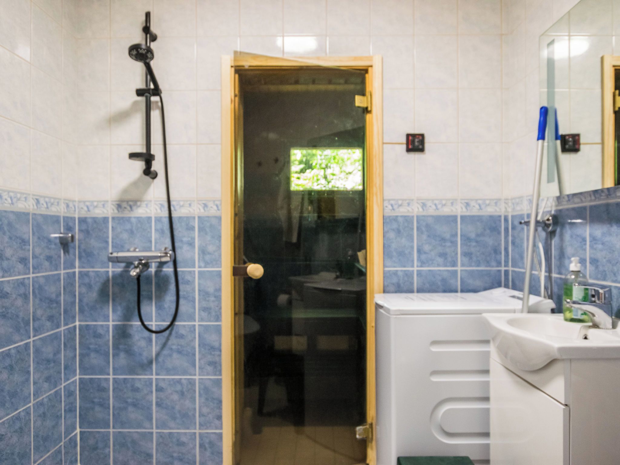 A bathroom with a shower, a sink, and a mirror.