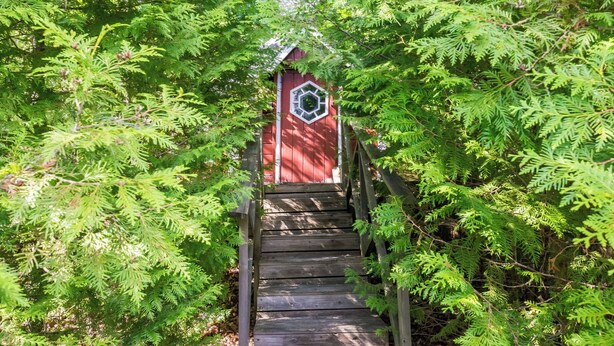 A wooden staircase leading to a red building with a white window. - Palttala by Interhome (Tampere)