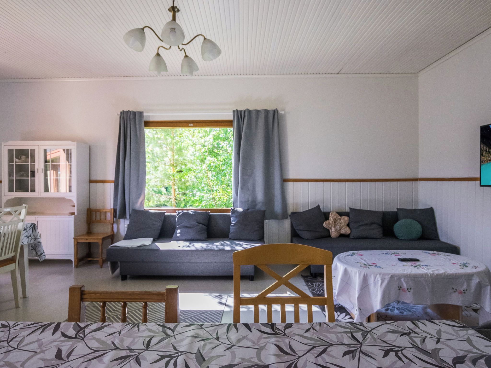 Una habitación con cama, una mesa, una silla, un armario y una ventana con cortinas.