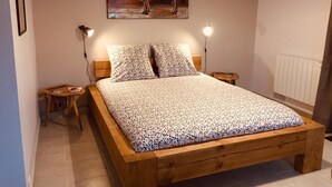 Ein Schlafzimmer mit einem Holzbett, zwei Nachttischen, einer Wandlampe und einem Bild von einem Stier.
