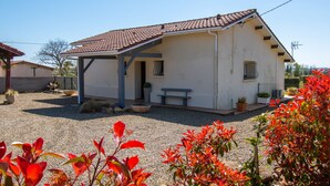 A small, single-story house with a tiled roof, a covered porch, and a bench. - Furnished house F3 on one level in Landes Chalosse in a gourmet region. (saint geours d auribat)