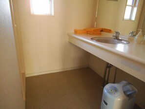 Une salle de bain avec un lavabo blanc, un miroir et un porte-serviettes.