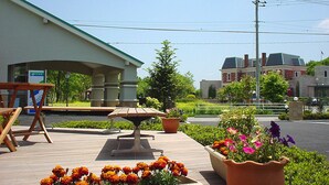 An outdoor area with a wooden bench, a table, and flower planters. - Family Lodge Hatagoya Nasu (Nasu)
