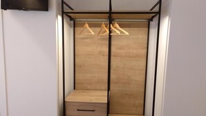 A walk-in closet with a wooden interior, a black metal frame, and a flat-screen TV mounted on the wall. - Hotel Entrerailes (Casalarreina)