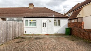 A residential property with a paved driveway, a white door, and a brick wall. - HiikotsHomes - Dartford (Dartford)