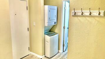 A laundry room with a washing machine, dryer, and a water dispenser.