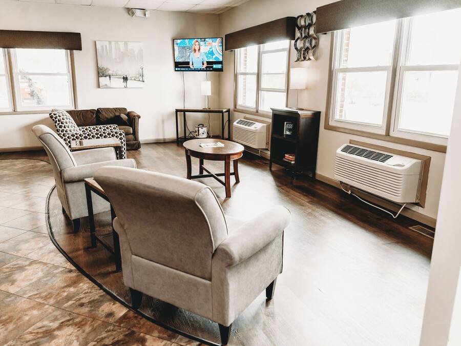 A spacious living room with a large window, a flat-screen TV, a fireplace, and a comfortable seating area.