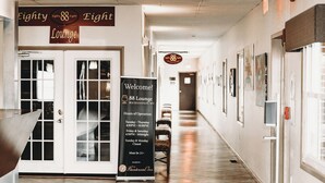 Un couloir avec une enseigne indiquant l’emplacement du « Eighty Eight Lounge », ainsi que les heures d’ouverture et un message de bienvenue.