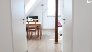 A narrow hallway with wooden flooring leading to a dining area with a table and chairs. - Schwaben Apartment (Oberboihingen)