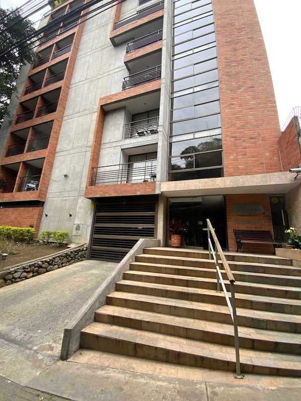 Um edifício com vários andares e uma escadaria que leva à entrada.