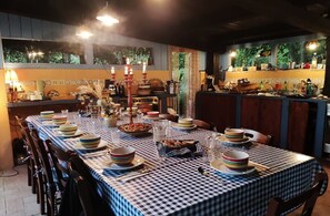 A dining area with a checkered tablecloth, multiple candles, and a variety of dishes and glasses. - Glamping with Silence, Nature, and Comfort in the Heart of Tuscany (Santa Fiora)
