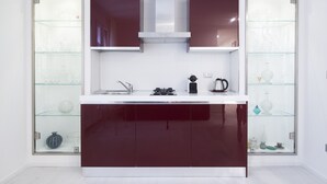 Uma cozinha moderna com ilha central, armários com portas de vidro e eletrodomésticos de aço inoxidável.