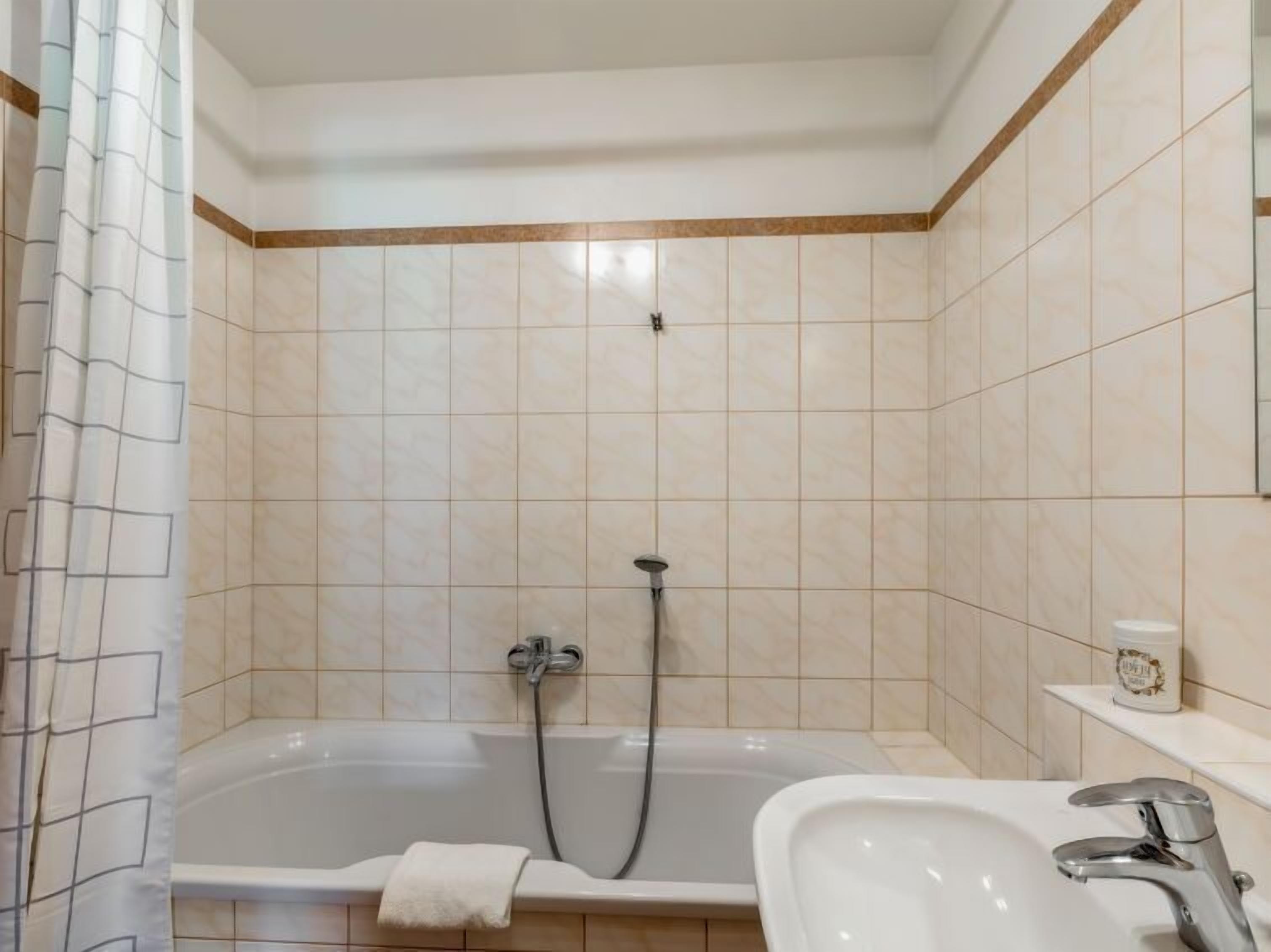 Ein Badezimmer mit einer Badewanne, einem Waschbecken und einer Dusche.