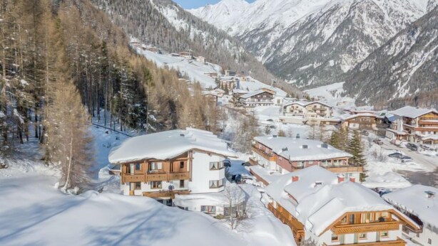 A snow-covered mountain village with chalet-style buildings, a ski lift, and a clear view of the surrounding mountains. - Apartment Alpin by Interhome (Sölden)
