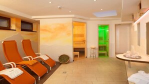 A spa room with orange chairs, a green-lit sauna, and a skylight. - Apartment Alpin by Interhome (Sölden)