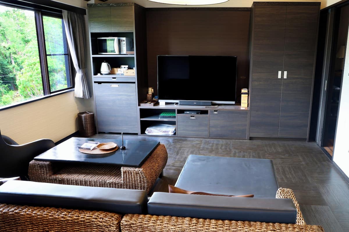 A modern living room with a flat-screen TV, built-in cabinets, and a seating area with a table.