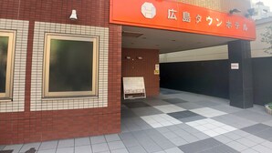 Un bâtiment dont la façade est recouverte de carreaux et qui arbore une grande enseigne orange avec du texte blanc.