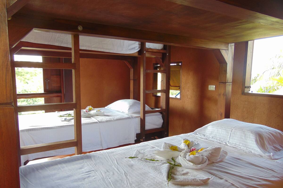 Ein Zimmer mit zwei Betten, Holzbalken und einem Fenster.