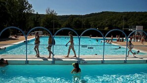 Una piscina con plataforma de salto y quiosco de socorristas.