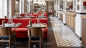 A restaurant with red booths, wooden chairs, and a patterned floor. - Villa Copenhagen (Copenhagen)