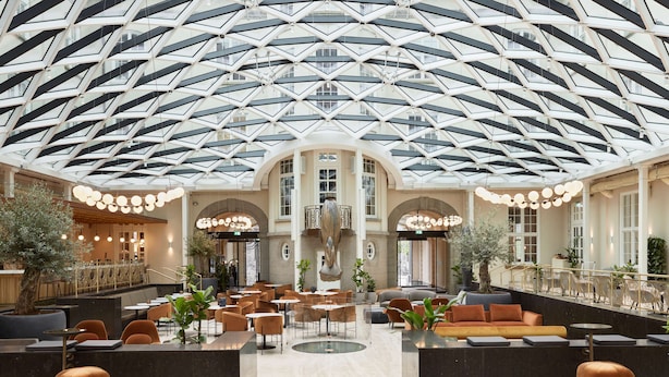 A spacious lobby with a high ceiling, multiple seating areas, and a central fountain. - Villa Copenhagen (Copenhagen)