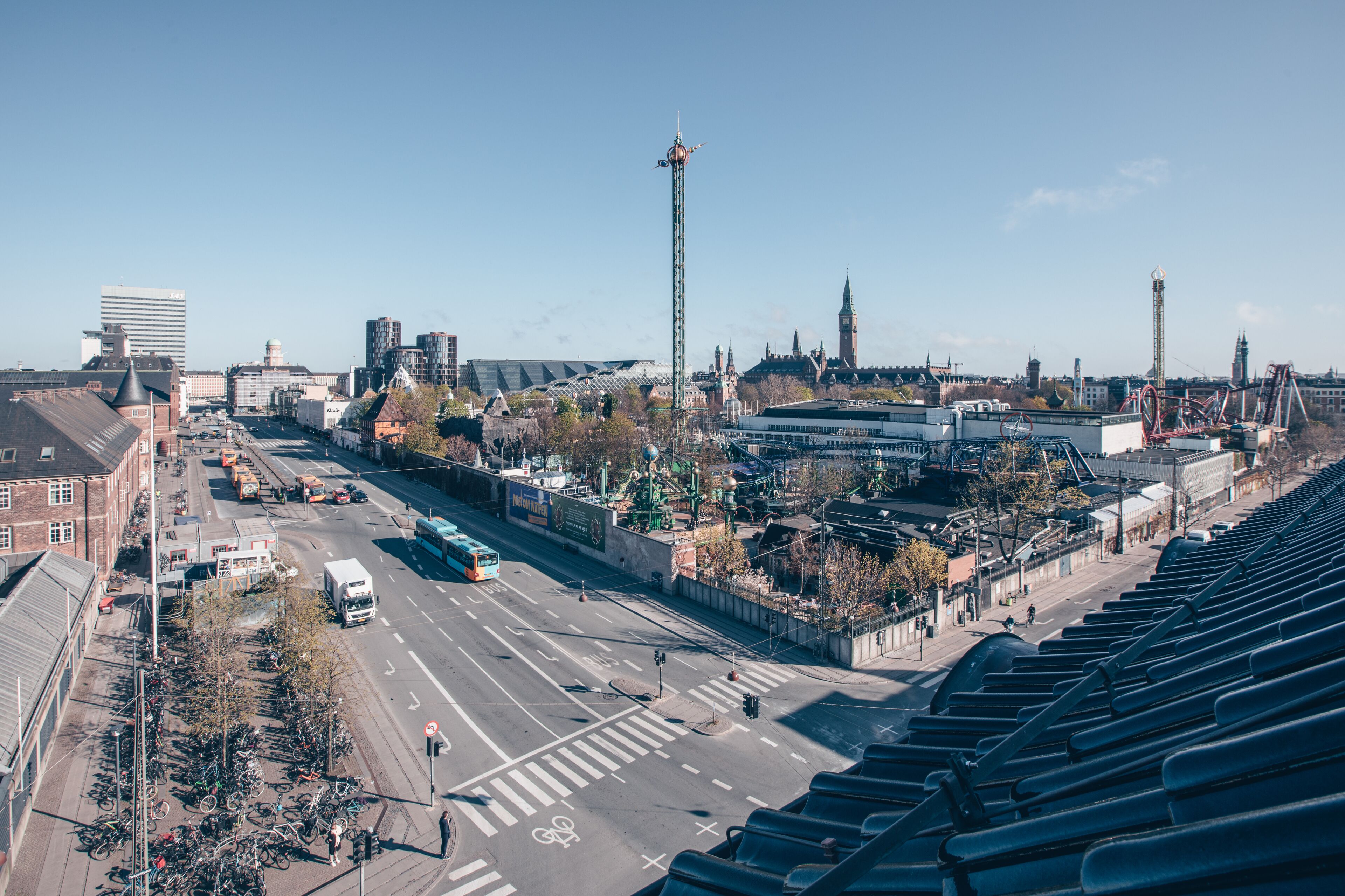 An aerial view of a cityscape with a prominent tower, a historic building, and a modern structure.