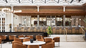 A spacious bar area with high ceilings and a modern design, featuring multiple seating arrangements and a well-stocked bar counter. - Villa Copenhagen (Copenhagen)