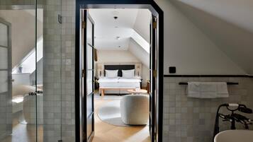 A modern bathroom with a bathtub, a glass shower enclosure, and a visible toilet.