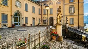 Ein Innenhof mit Brunnen, Statue und einem Gebäude mit einer Uhr.