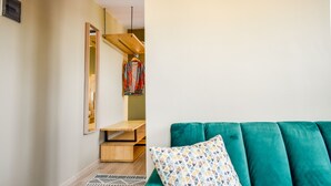 A modern living room with a teal sofa, patterned cushions, and a geometric rug.
