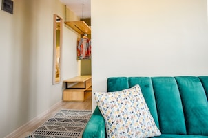 Una sala de estar moderna con un sofá azul aguamarina, cojines estampados y una alfombra geométrica.