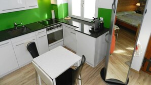 Une cuisine compacte équipée d’une cuisinière, d’un évier et d’un petit coin repas avec une table et des chaises.