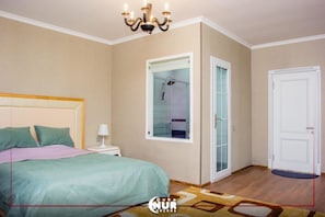 Un dormitorio con cama, mesita de noche, lámpara y espejo.