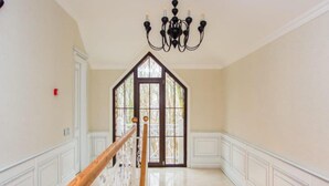 A staircase with a wooden handrail leading to a door with a stained glass window. - Gachresh Forest Resort (Quba)