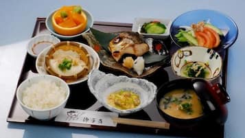 A tray with various Japanese dishes including rice, soup, and fish.