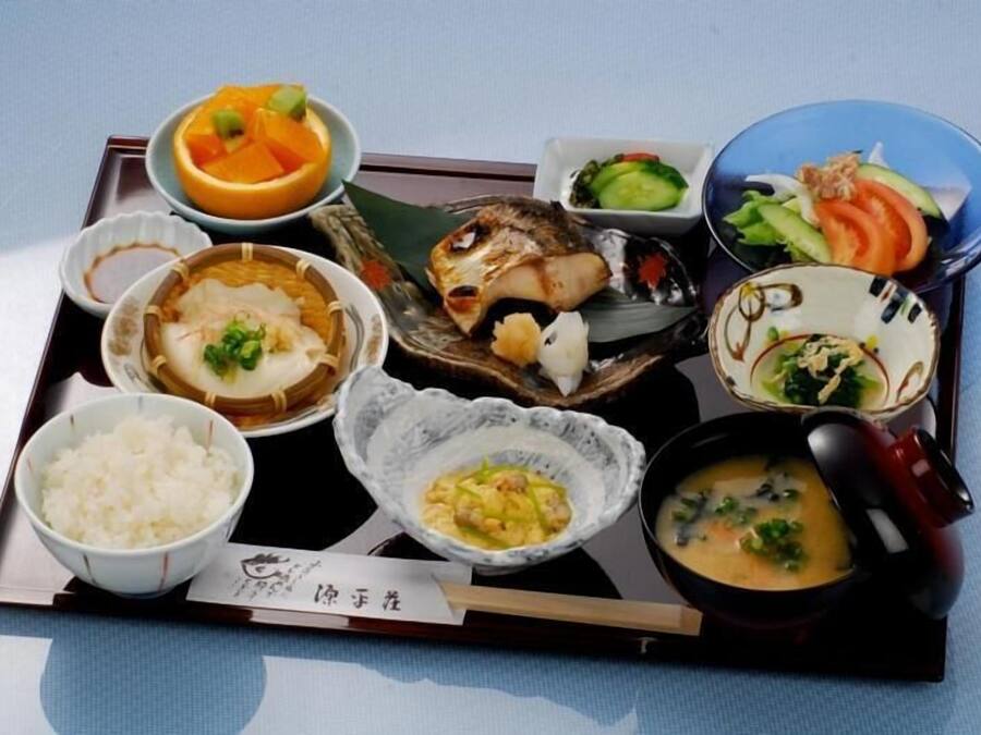 A tray with various Japanese dishes including rice, soup, and fish.