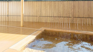 A wooden deck with a pool, a wooden fence, and a view of green hills. - Amagi Onsen Zen no Yu (Kawazu)