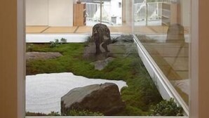 A modern interior with a glass partition, a view of a landscaped outdoor area, and a wooden floor. - Amagi Onsen Zen no Yu (Kawazu)